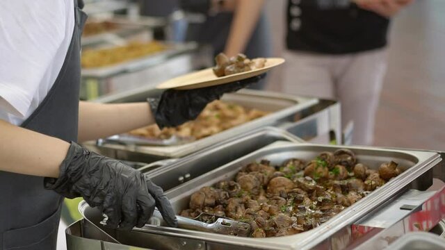 Hands of cook giving food to customer at a catered event, catering