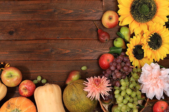 Happy Thanksgiving concept, autumn background with seasonal fall nature berries, pumpkins, melons, apples, grapes and flowers on wooden background, top view, copy space, flat lay.