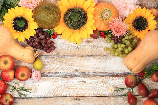 Thanksgiving, autumn background with seasonal nature fall berries, watermelons, melons, wheat, apples and flowers on wooden background, top view, copy space, flat lay. Happy Thanksgiving concept,