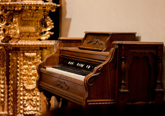Fototapeta na wymiar Old piano, relic of the historical museum of Peru in Cusco. Wooden organ and Relics of Pure Gold, Museum in Latin America.