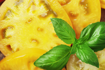Yellow juicy tomatoes with basil close up