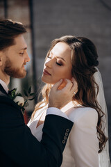 Portrait of stylish newly married European couple. The bride in a veil and white dress