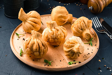 Georgian deep-fried Khinkali dumplings with meat on a wooden round tray