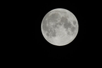 Naklejka na ściany i meble A full moon in a dark black sky over Camp Verde, Yavapai County, Arizona.