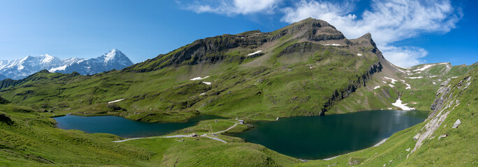 Fototapeta na wymiar panorama sur deux lacs de montagne au milieu des prairies des alpes