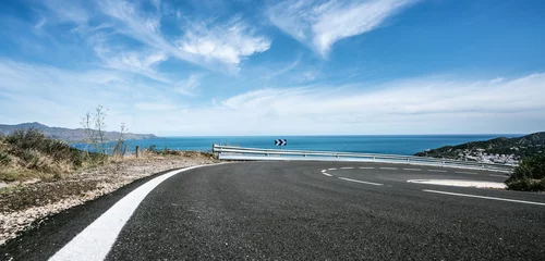 Fototapeten Mediterranean sea coast road into mountains horizon in summer with beautiful bright sun rays © AA+W