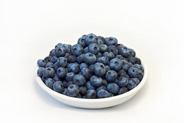 Fresh blueberries in white plate on white background