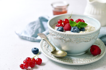 Oatmeal porridge with fresh berries and maple syrup for a breakfast.