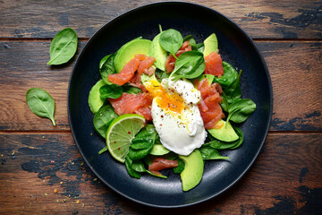 Healthy breakfast : green vegetable salad with salted salmon and poached egg. Top view with copy space.