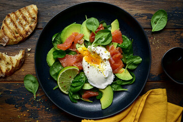 Healthy breakfast : green vegetable salad with salted salmon and poached egg. Top view with copy space.