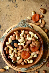 Wooden bowl with assortment of dried fruits and nuts. Top view with copy space.