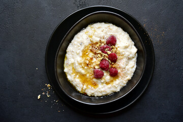 Oat porridge with nuts and maple syrup for a breakfast. Top view with copy space.
