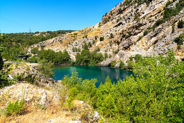 Fototapeta na wymiar Green Canyon - one of the main attractions of Turkey. Natural beauty of Turkey. Mountains, green pines, turquoise lake. Mountain landscape with forest, trees. Beautiful mountain lake backround. Rocks.