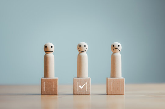 Customer satisfaction survey concept, service, rating, wood doll standing on wood block with checkbox happy face.