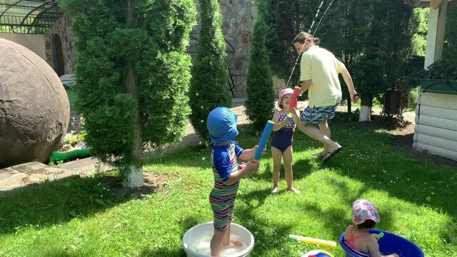 Cute Happy Kid Little Preschool Baby Girl and Boy Child Play Have Fun with Water Pump Gun Outside. Sunny Hot Nice Day in Park. Children Backyard Garden Games. Summer, Sport, Holiday, Family, Childhood