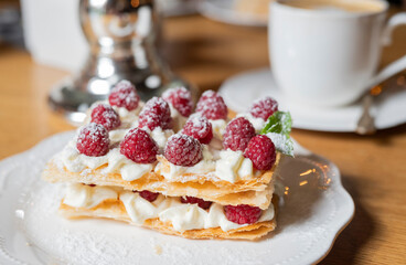 French slavdlka pastries milfey cake with cream and shortcakes and raspberries in a restaurant