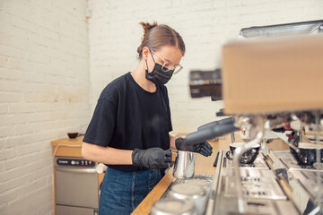 Female person whiping milk in cappuccino maker