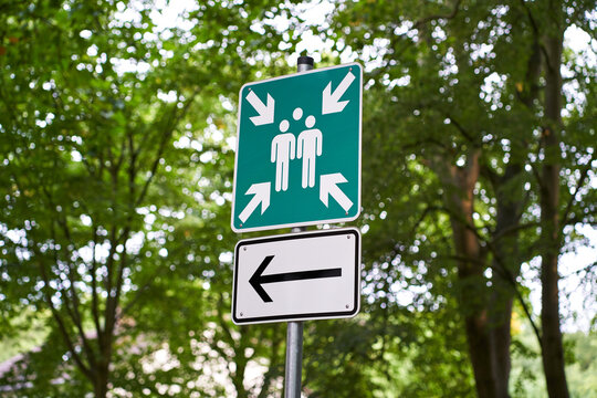 Assembly point sign with directional arrow.