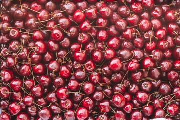 Background image of lying red ripe sweet cherries. Top view, flat lay. Copy space