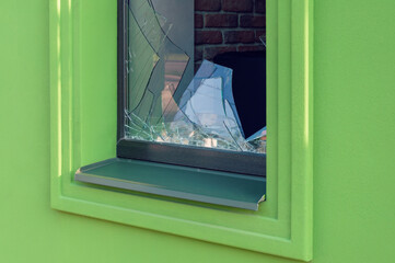 Broken green facade window glass in close-up