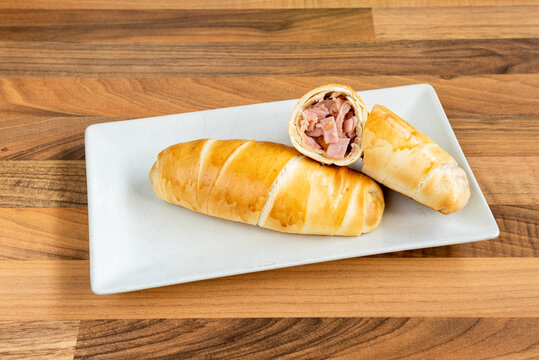 Venezuelan cachito stuffed with sliced ham and fresh cheese for breakfast