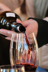 Waiter serving red wine in a glass