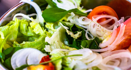 closeup salad with lettuce, onion, tomato and basil
