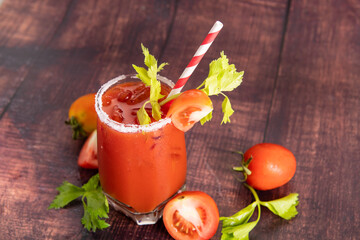 glass glass of tomato juice with fresh bright tomatoes, green parsley  on a dark background. vegetable drink.