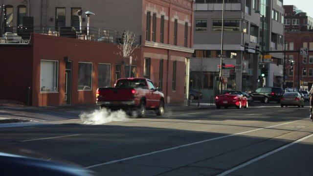 Smoke Rising From Asphalt Road With Vehicles Driving In Denver, Colorado At Daytime. static
