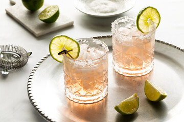 Refreshing margarita mocktails with salted rims and garnished with lime slices, ready for drinking.