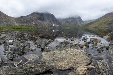 Landscape of Grizzly Lake in northern Canada, Yukon, sub arctic area with pristine water below massive mountain peaks. 