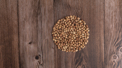 Top view macro close-up on plenty of dry cardamom spice on wooden background, horizontal format, with copy space for text.
