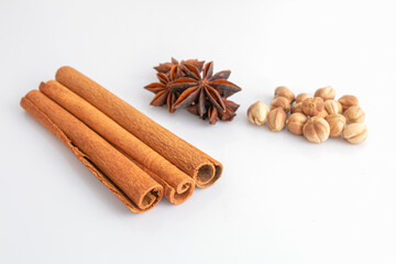 Cinnamon sticks, Anise stars, and dry cardamom on a white background. Selective focus