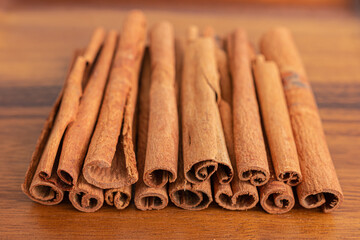 Close up shot of aromatic dry cinnamon sticks on wooden table background, Selective focus