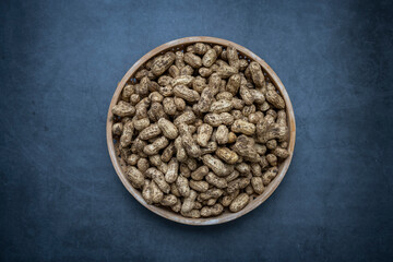 Fresh peanuts with dirt on a dark gray background