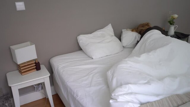 Pan right, woman sleep on her own in a double bed, minimalist bedroom decoration