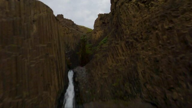 FPV drone flies up a waterfall and than dives down-stream in Iceland