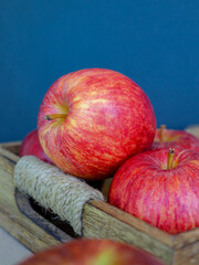 Red apples in a wooden box on table