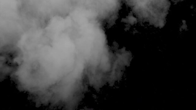 Spooky magic Halloween. Atmospheric smoke VFX element. Haze background. Abstract smoke cloud. Smoke in slow motion on black background. White smoke slowly floating through space against black bg