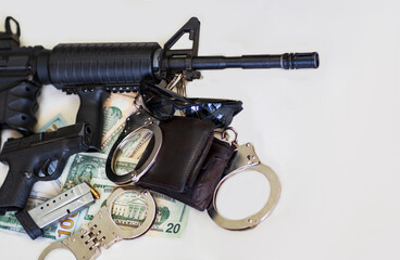 Obraz premium Modern automatic rifle, Pistol, gun and bullets 9mm ammunition, handcuffs on American dollars banknotes. Criminal money and punishment, Copy space. Legendary U.S. Army Handgun with assault rifle.