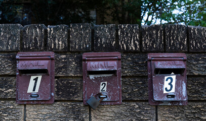 Three letter boxes in a brick wall. 