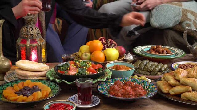 Authentic muslim family around the table. Traditional festive islamic halal meals and food. Celebrating Eid al-Fitr