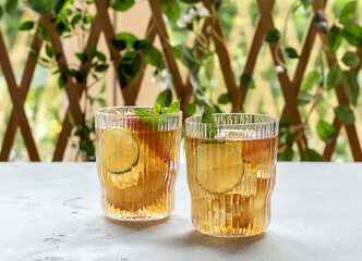 Two glasses with homemade peach ice tea or lemonade with mint.