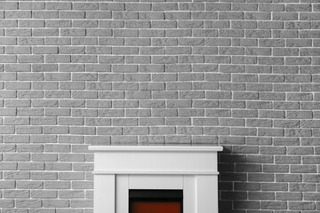 Obraz na płótnie Canvas Modern fireplace near brick wall
