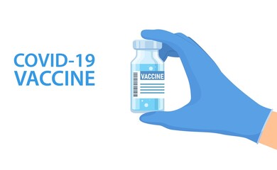Hand in gloves holds bottle of vaccine.