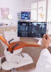 Specialist orthodontist doctor holding teeth surgery radiography working in medical dentistry stomatology hospital office room. Radiologist analyzing tooth jaw expertise in oral examination clinic