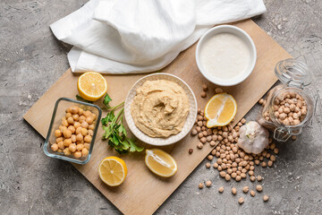 Composition with tasty hummus and ingredients on grunge background