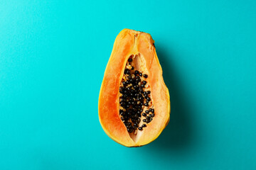 Summer composition. Tropical papaya fruits cut in half lie on a blue background. Summer concept....