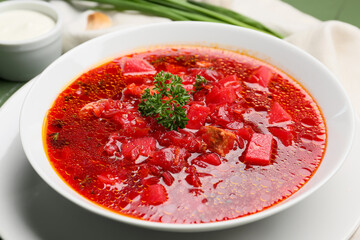 Bowl with tasty borscht on table