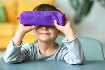 Little boy with pencil case at home